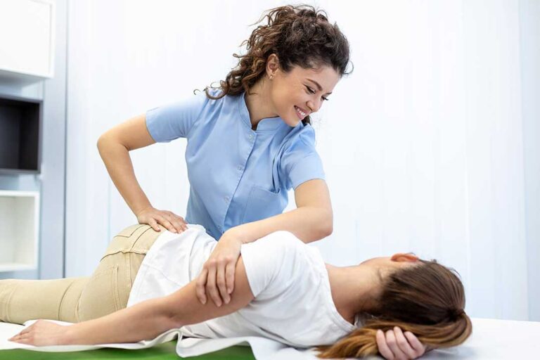 A chiropractor gently assessing the spine of an adult patient in a bright clinic setting.